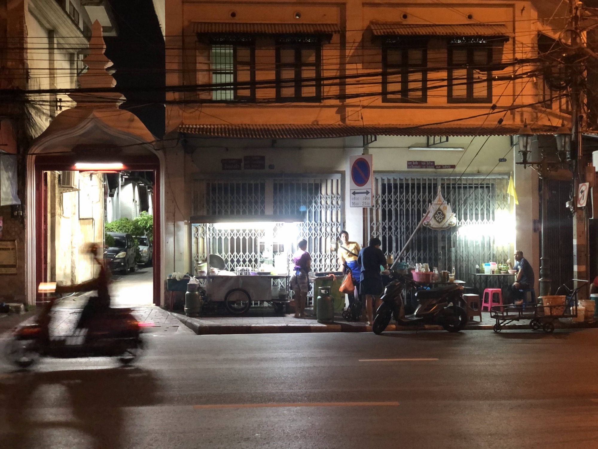 Foodstalls lit up at night in front of old shophouses in Bangkok's old town