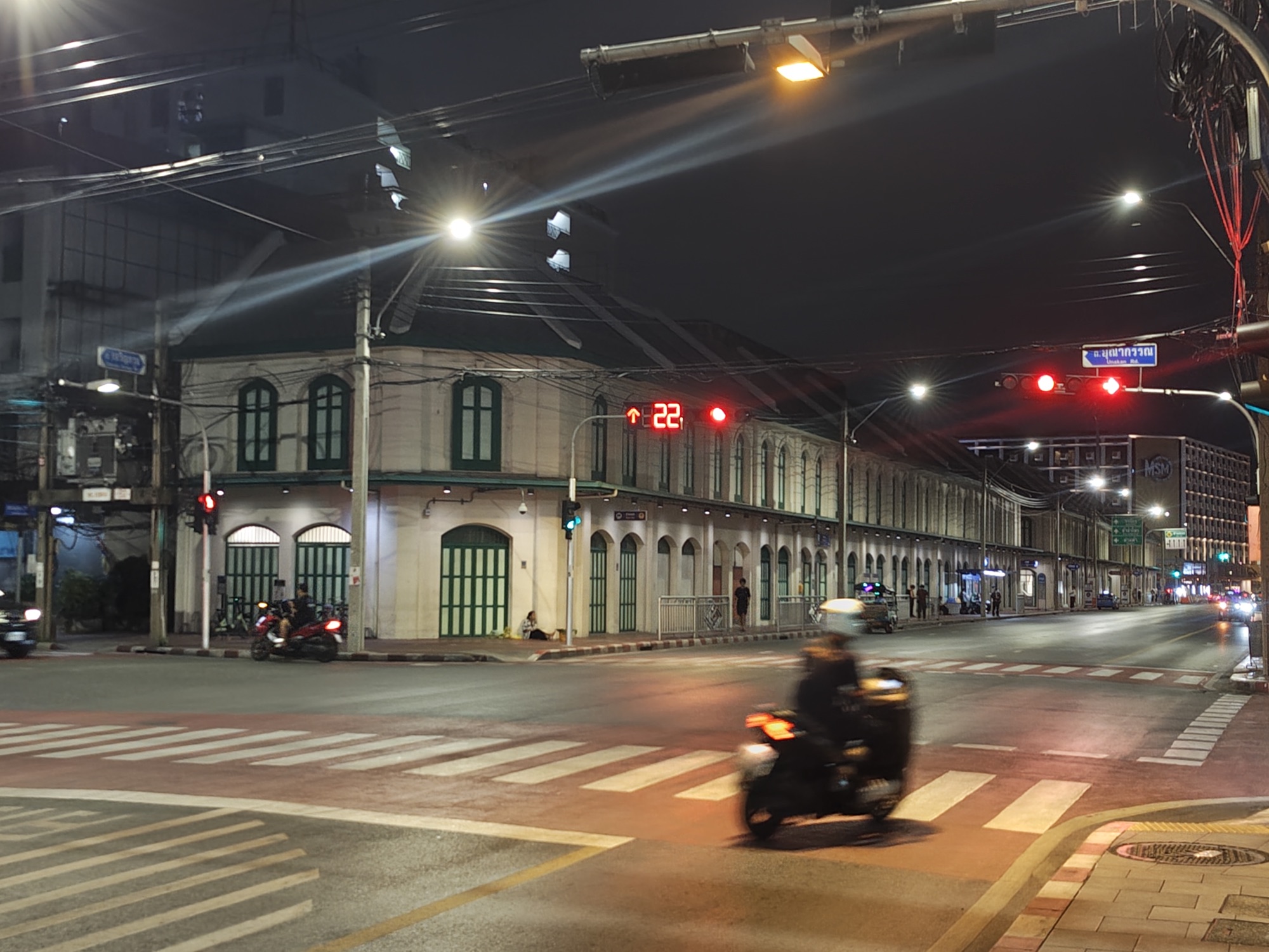 Old town shophouses lit at midnight on an empty Bangkok street corner